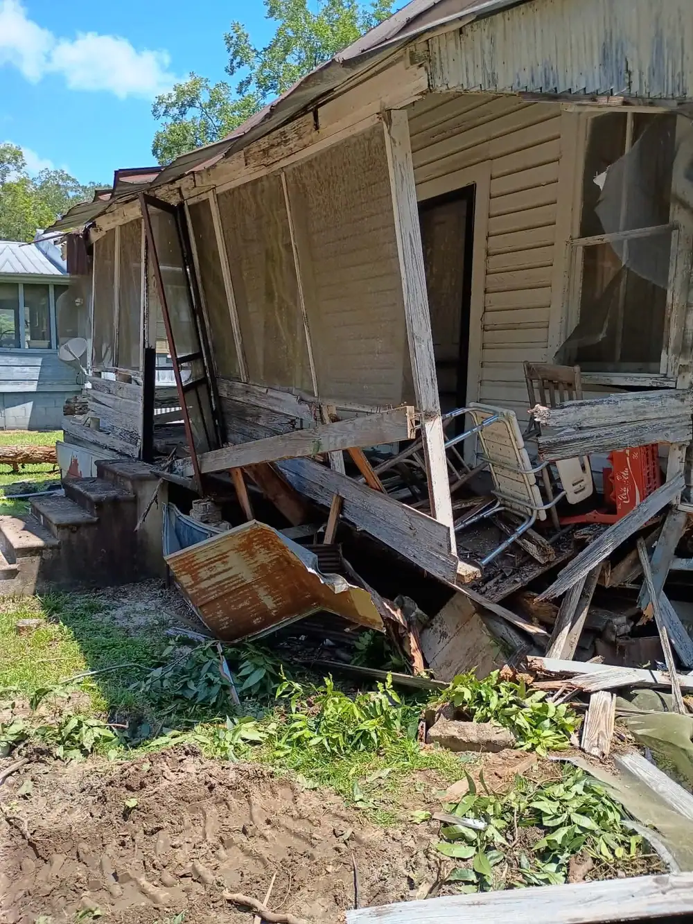 Old frame house with a collapsing porch, before demolition