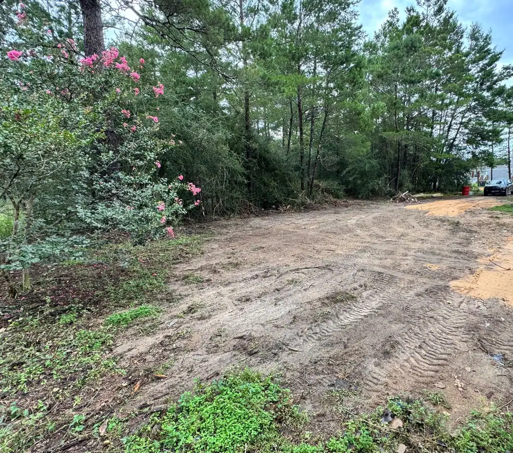 Wide path cleared through wooded land, ready to become a driveway